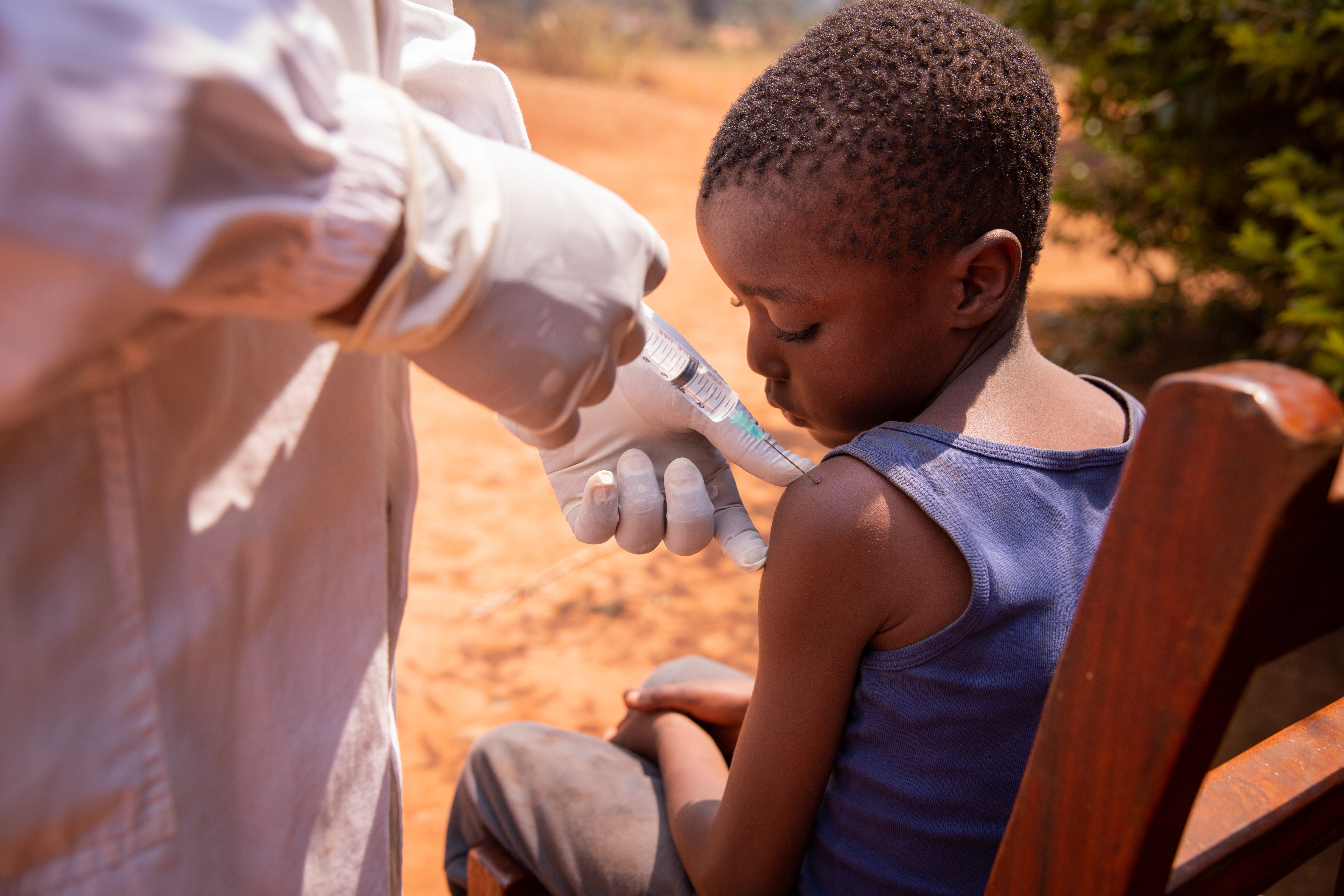 Close-up of a doctor injecting the vaccine to a child in africa.